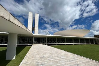 Vista externa do Congresso Nacional do Brasil sob um céu claro.